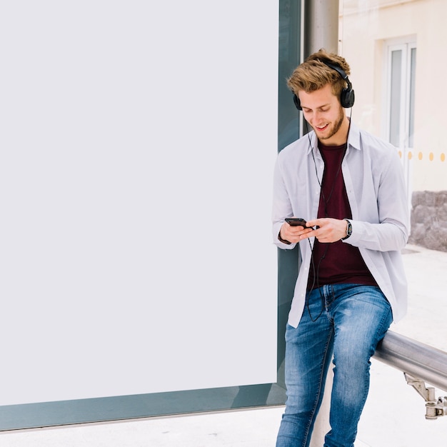 Gelukkige mens het luisteren muziek met oortelefoon