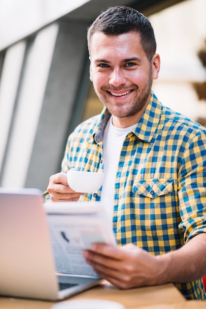 Gratis foto gelukkige mens met koffie in ochtend