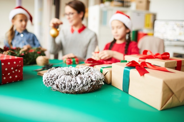 Gelukkige moeder en dochters die kerstcadeautjes inpakken