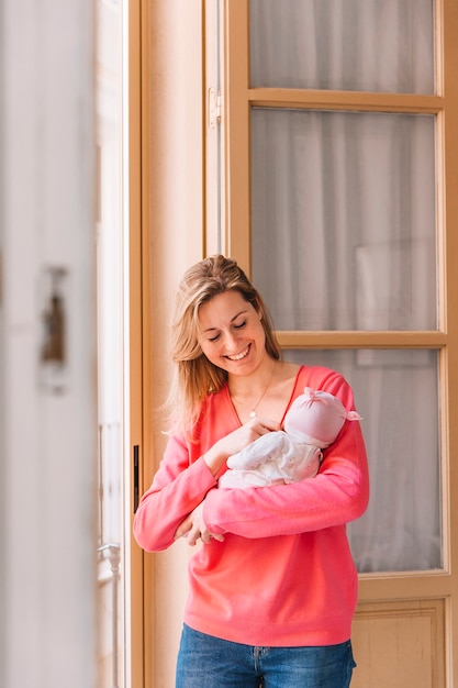 Gelukkige moeder met baby voor venster