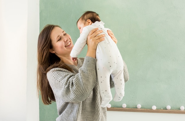 Gelukkige moeder spelen met schattige baby