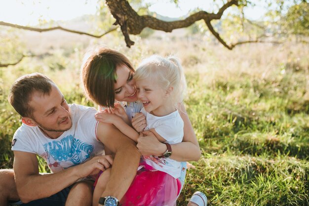 Gelukkige mooie familie op de grote tuin op de dageraadtijd