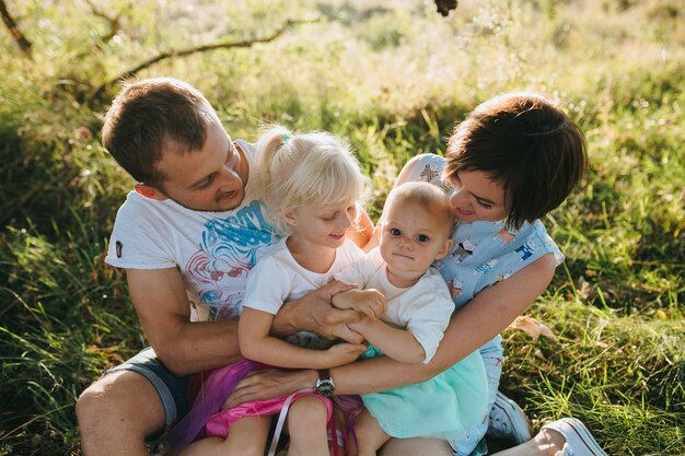 Gelukkige mooie familie op de grote tuin op de dageraadtijd