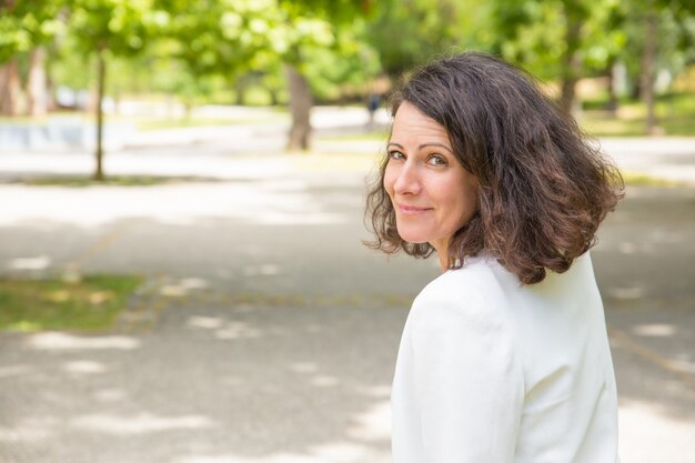 Gelukkige mooie vrouw die in park loopt