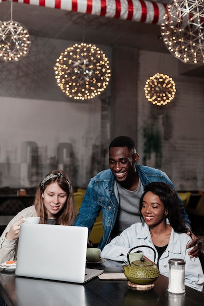 Gelukkige multiculturele vrienden die laptop bekijken