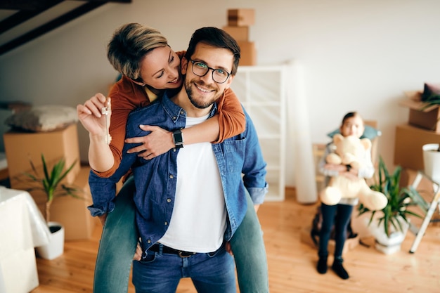 Gelukkige ouders die plezier hebben tijdens het verhuizen naar een nieuw huis met hun dochter