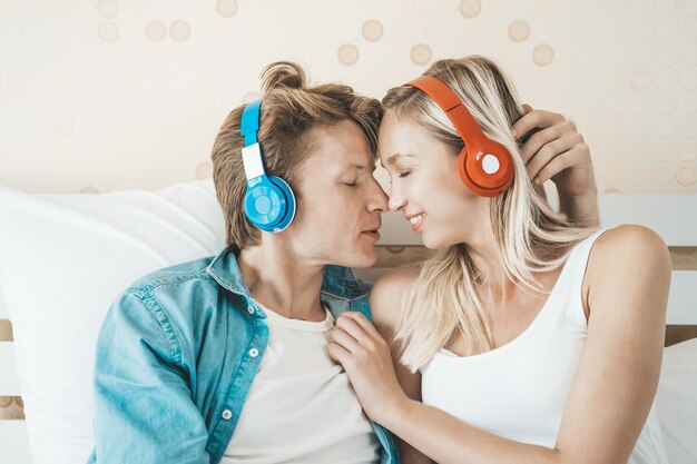 Gratis foto gelukkige paar luisteren lied in de ochtend in de slaapkamer