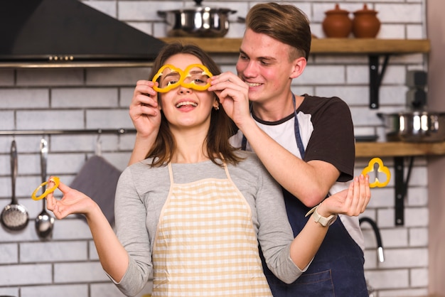 Gelukkige paar spelen met groenten in de keuken