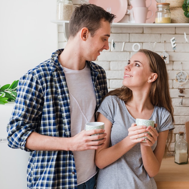 Gelukkige paar verliefd samen in de keuken op zoek naar elkaar