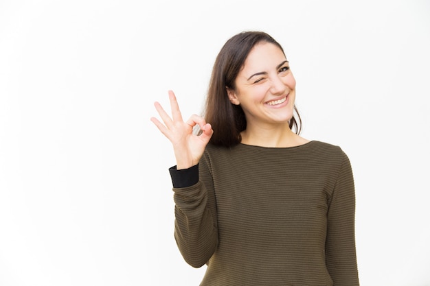 Gelukkige positieve mooie vrouw die Ok handgebaar maken