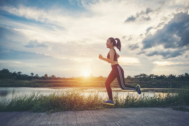 Gelukkige runner vrouw loopt in het park jogging oefening.