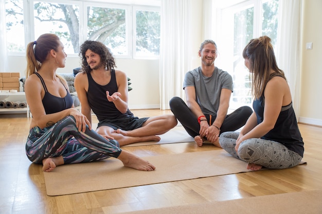 Gelukkige studenten die na yogaklasse babbelen