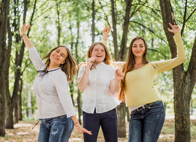 Gelukkige tienermeisjes die voor camera stellen