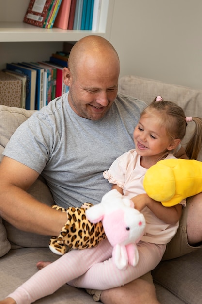 Gelukkige vader en dochter spelen met poppen