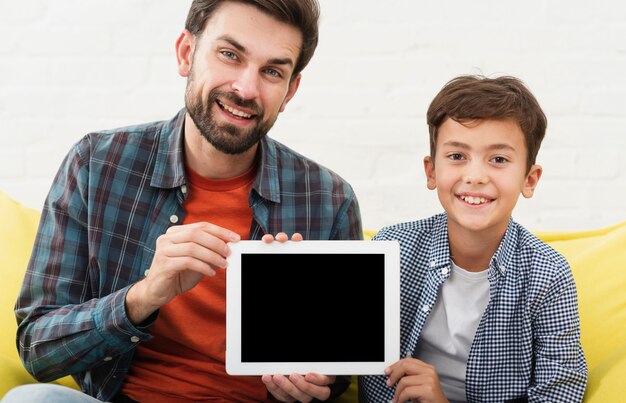 Gelukkige vader en zoon die een onechte foto houden