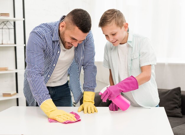 Gelukkige vader en zoon die van het schoonmaken genieten