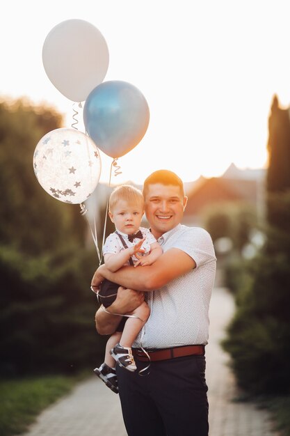 Gelukkige vader en zoon met luchtballonnen.