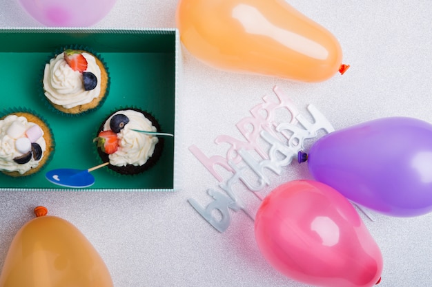 Gelukkige verjaardag inscriptie met cupcakes op tafel