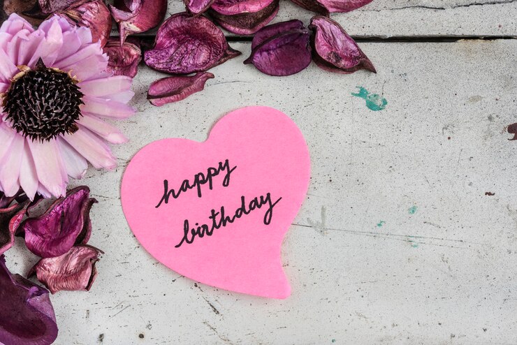 Gelukkige verjaardagskaart in hartvormpapier met roze bloemen