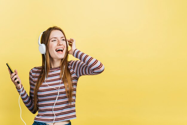 Gelukkige vrouw die aan muziek luistert