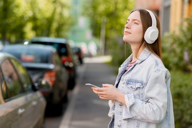 Gratis foto gelukkige vrouw die aan muziek luistert