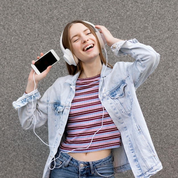 Gelukkige vrouw die aan muziek luistert