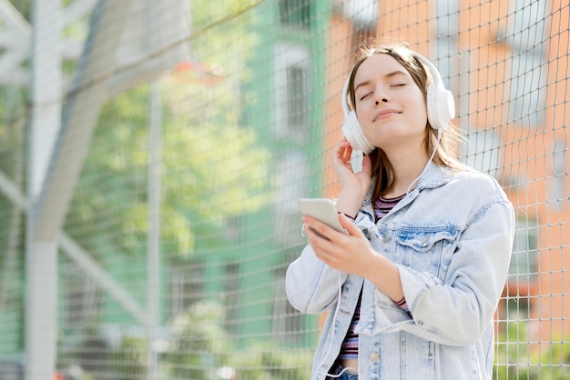 Gelukkige vrouw die aan muziek luistert