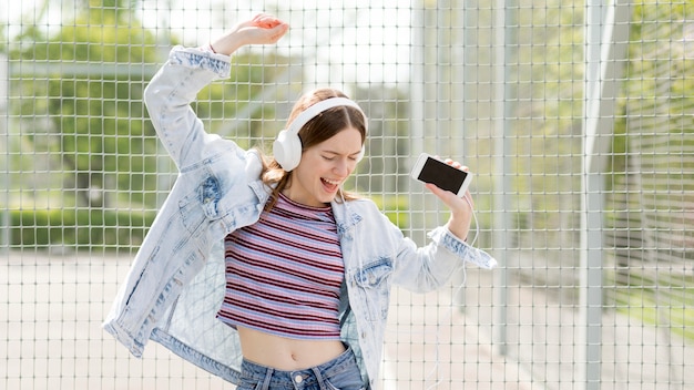 Gelukkige vrouw die aan muziek luistert