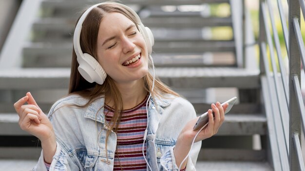 Gelukkige vrouw die aan muziek luistert