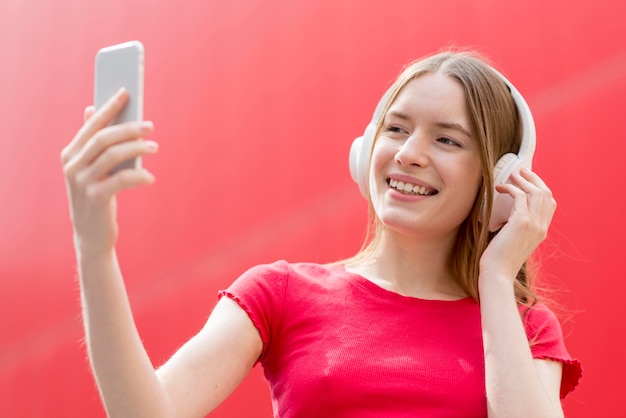 Gratis foto gelukkige vrouw die aan muziek luistert