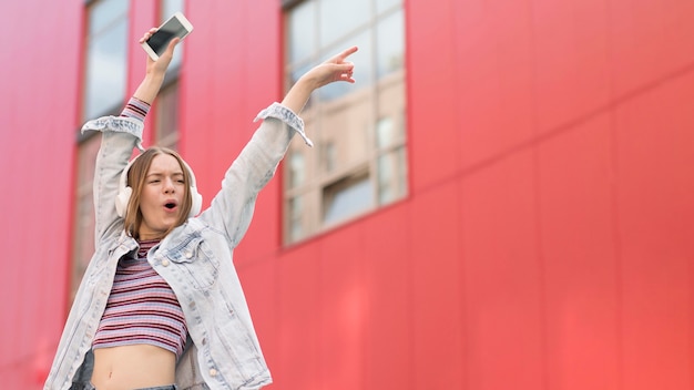 Gratis foto gelukkige vrouw die aan muziek luistert