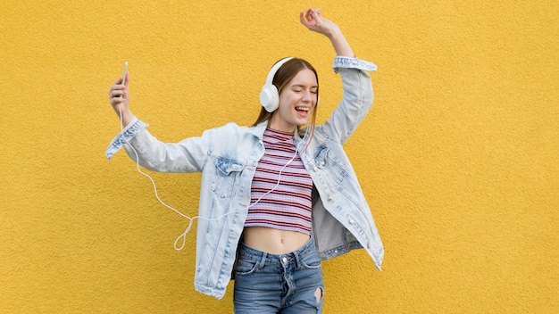 Gratis foto gelukkige vrouw die aan muziek luistert