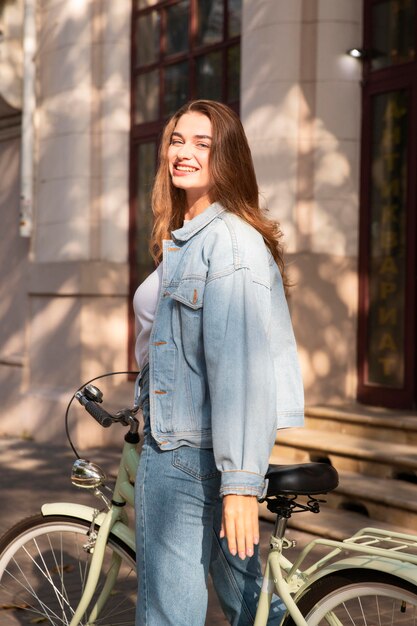 Gelukkige vrouw die haar fiets buiten in de stad berijdt