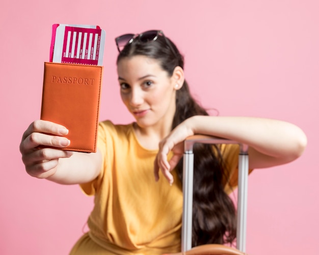 Gelukkige vrouw die haar paspoort houdt