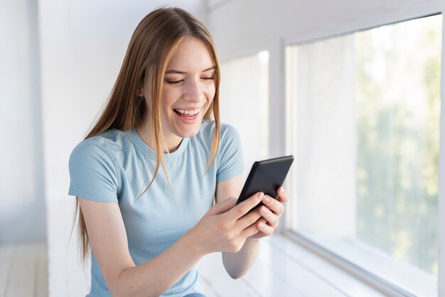 Gelukkige vrouw die haar telefoon controleert