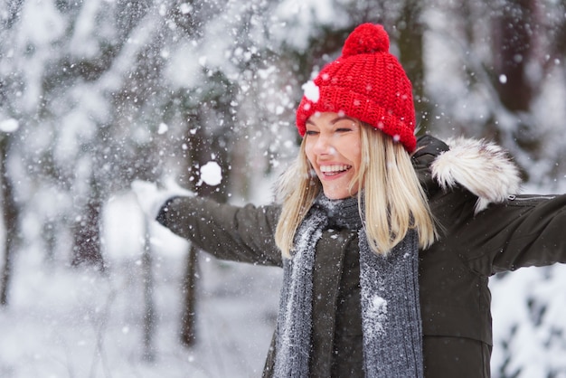 Gelukkige vrouw die onder sneeuwvlok danst