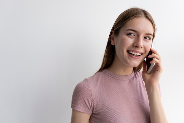 Gelukkige vrouw die op de telefoon met exemplaarruimte spreekt