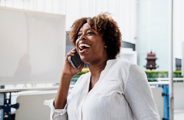 Gelukkige vrouw die op de telefoon spreekt