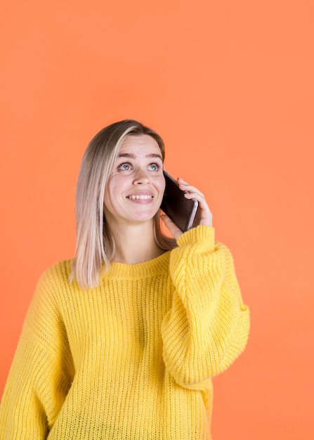 Gelukkige vrouw die op telefoon spreekt