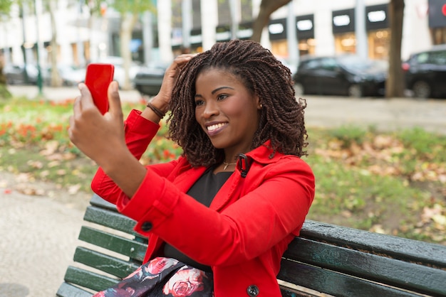 Gelukkige vrouw die smartphone in park gebruiken