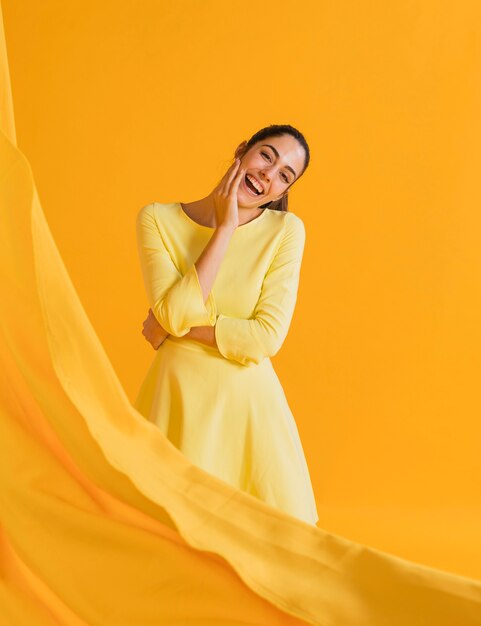 Gelukkige vrouw in gele jurk