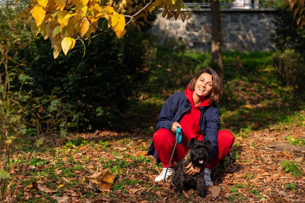 Gelukkige vrouw in park met herfstbladeren