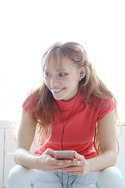 Gratis foto gelukkige vrouw luisteren muziek met koptelefoon