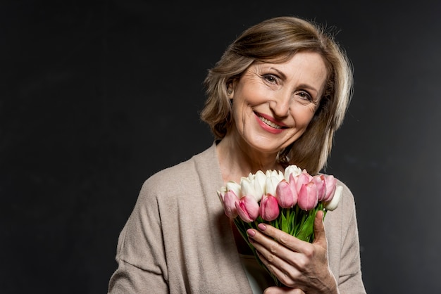 Gelukkige vrouw met boeket bloemen