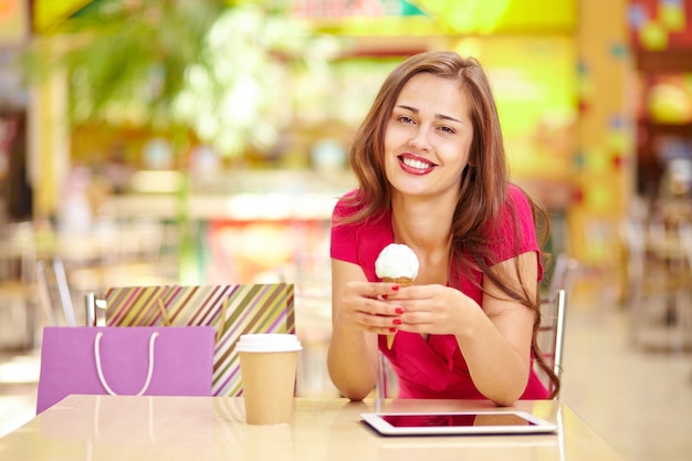 Gelukkige vrouw met een ijsje en koffie