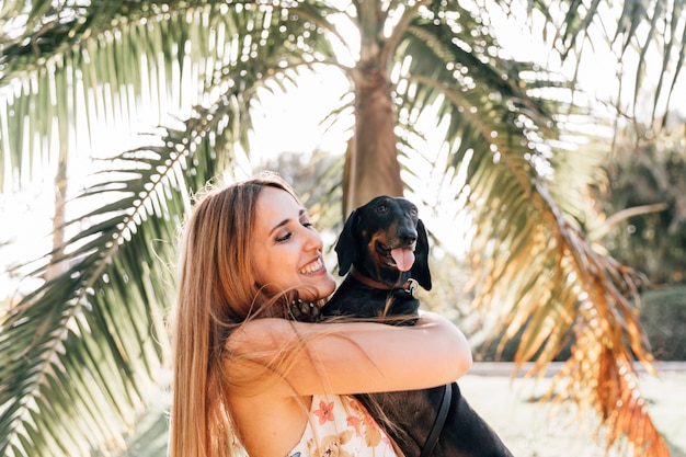 Gratis foto gelukkige vrouw met haar hond tong uitsteekt