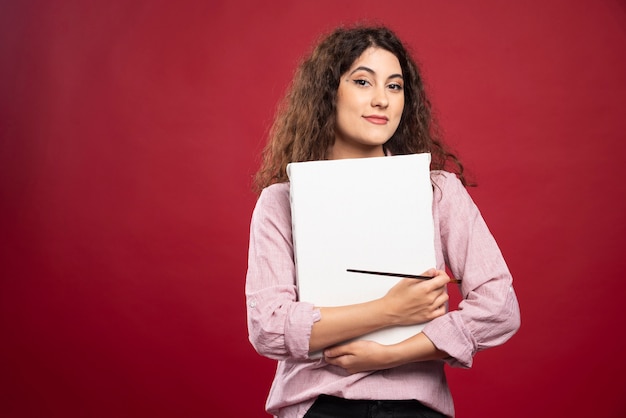 Gelukkige vrouw met penseel en canvas.