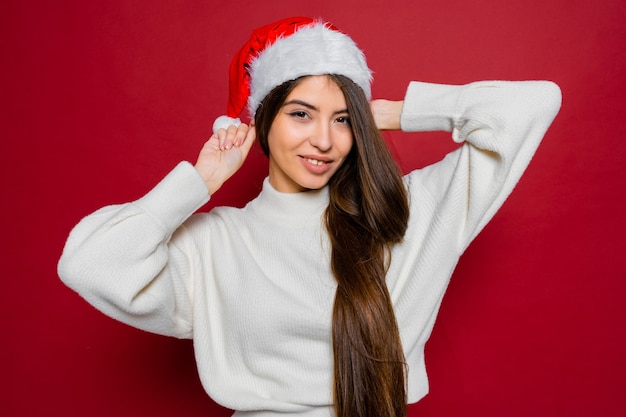 Gelukkige vrouw met verbazingwekkende lange haren in kerstmuts poseren