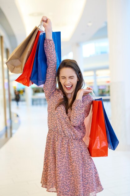 Gelukkige vrouw na grote shopping spree