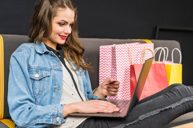 Gratis Foto gelukkige vrouw om thuis te zitten genieten van online winkelen